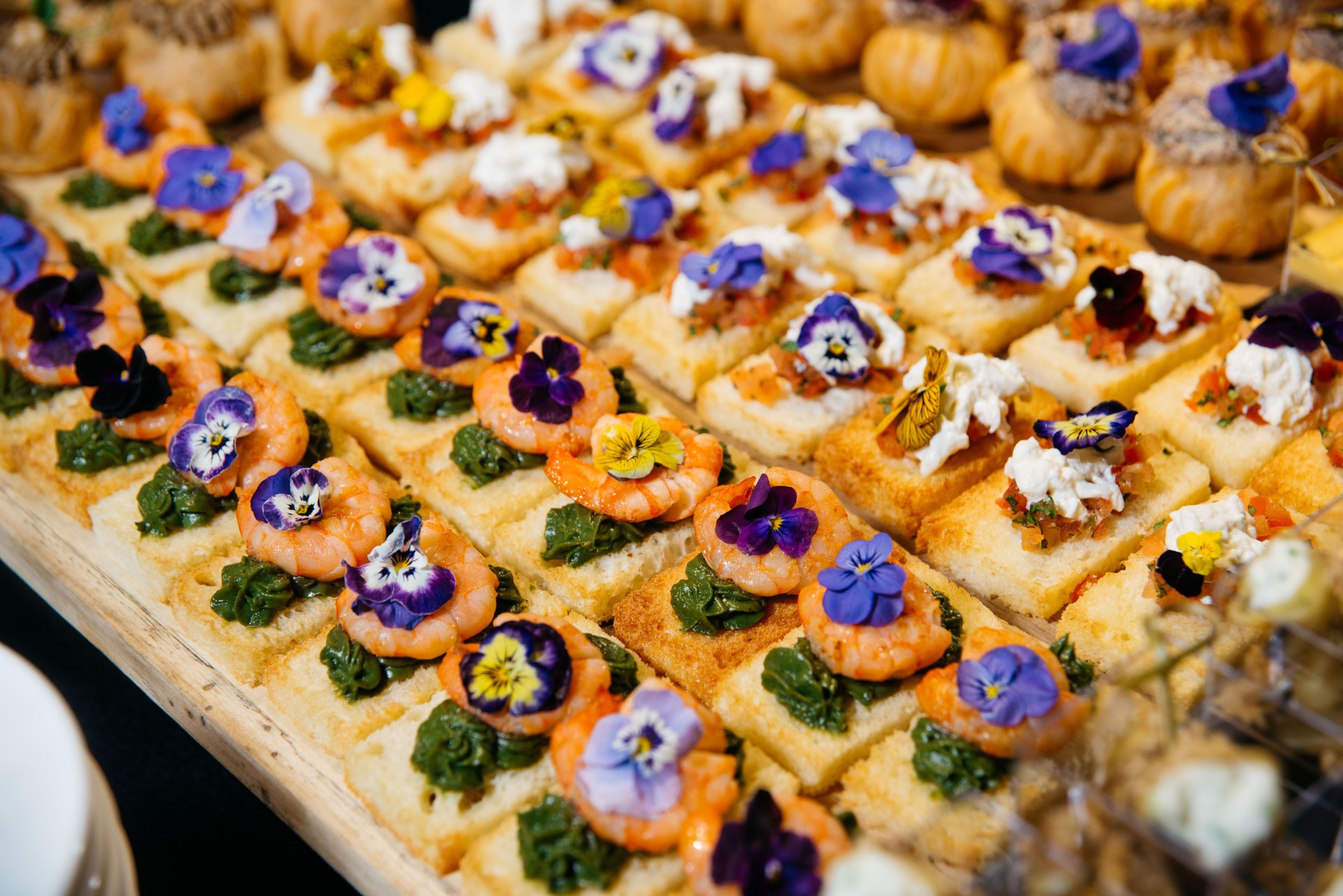 Canapés gourmands aux crevettes et bruschetta aux fleurs.